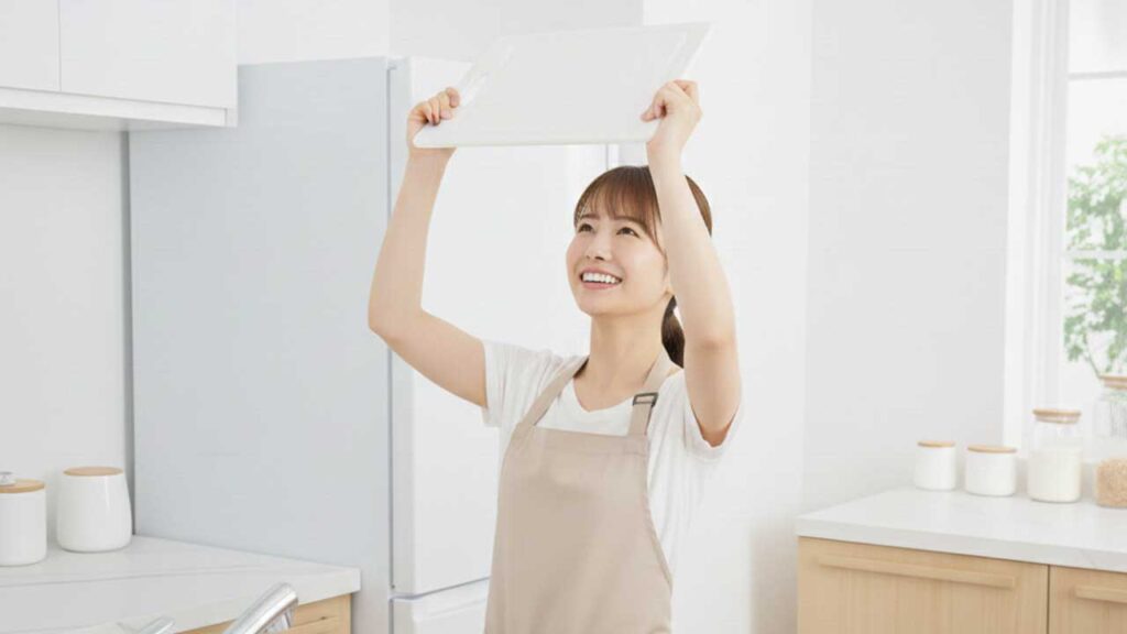 プラスチック製のまな板を持つ女性