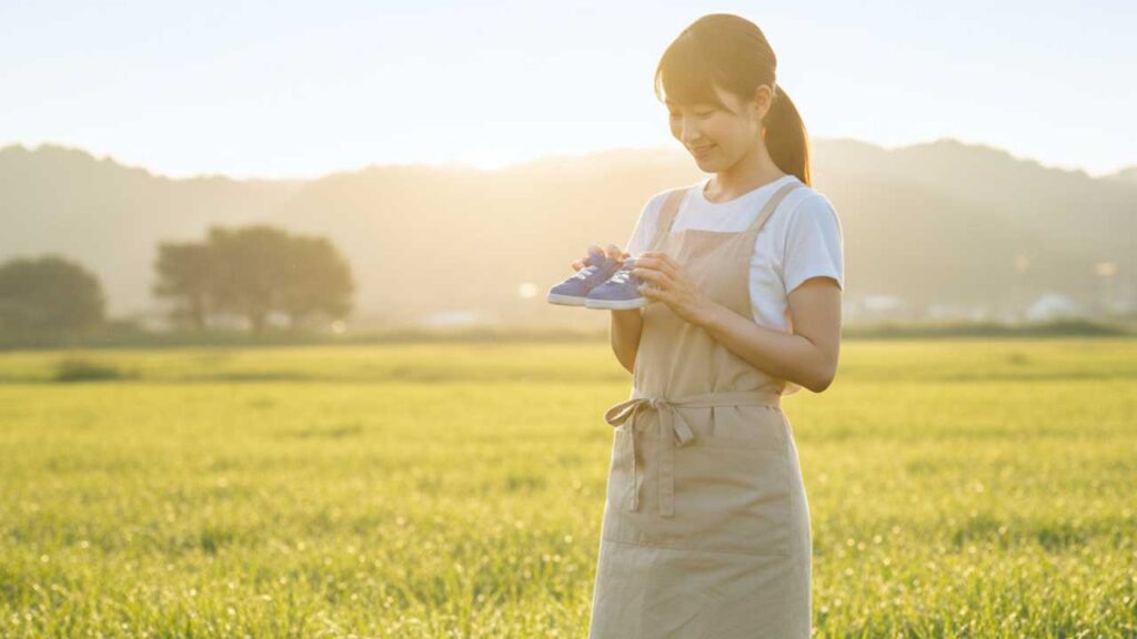 子供用の靴を持つ女性
